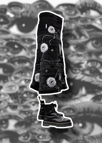 Repurposed black denim skirt with painted puffy eye balls and zig zag stitching on top