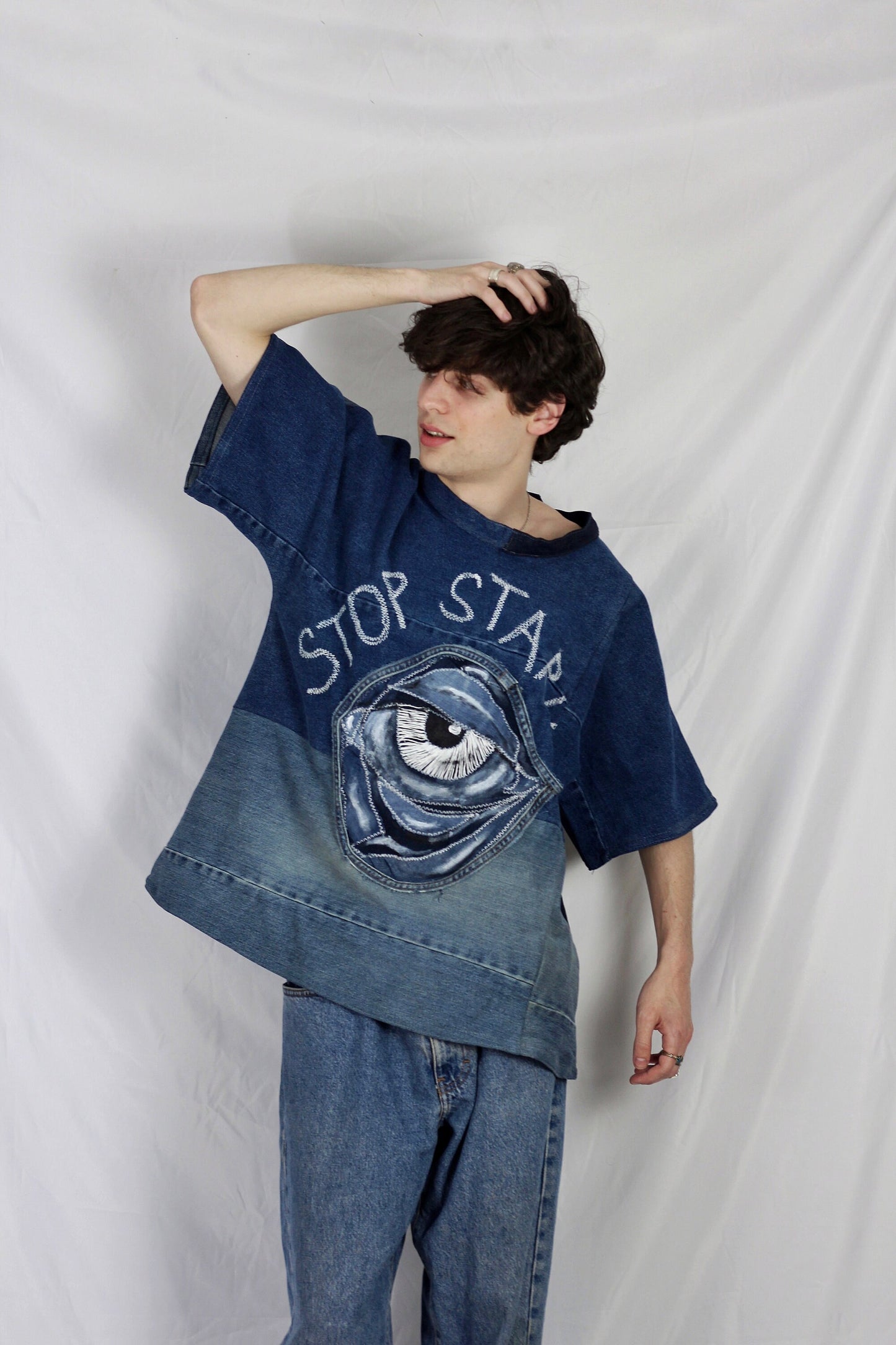 Baggy blue denim T-shirt with textured “Stop staring” title