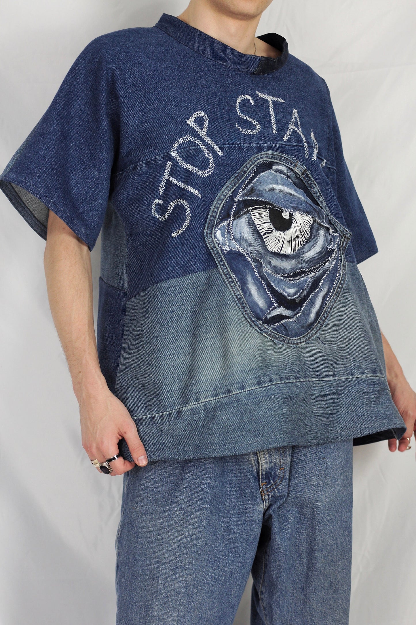 Baggy blue denim T-shirt with textured “Stop staring” title