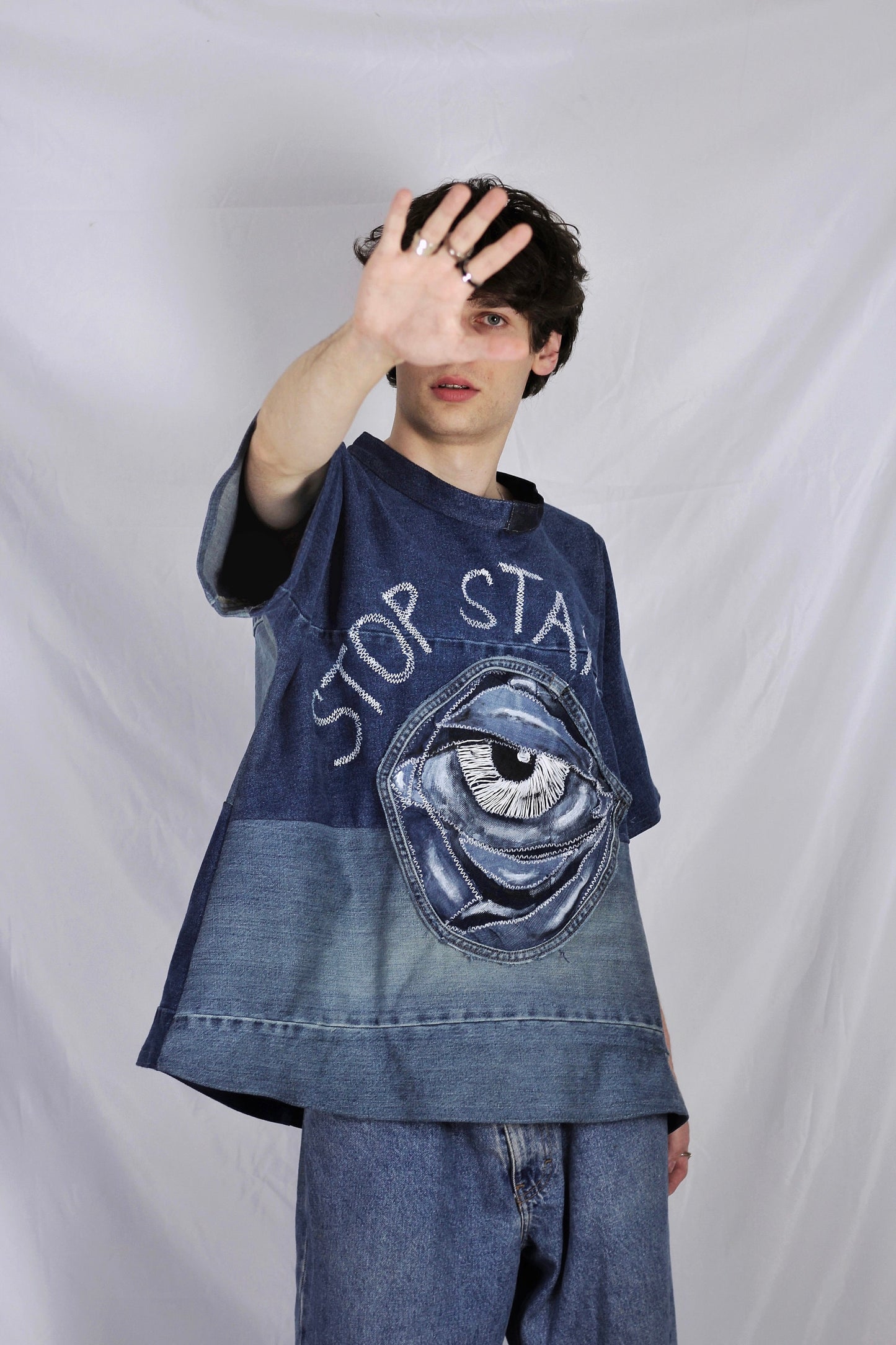 Baggy blue denim T-shirt with textured “Stop staring” title